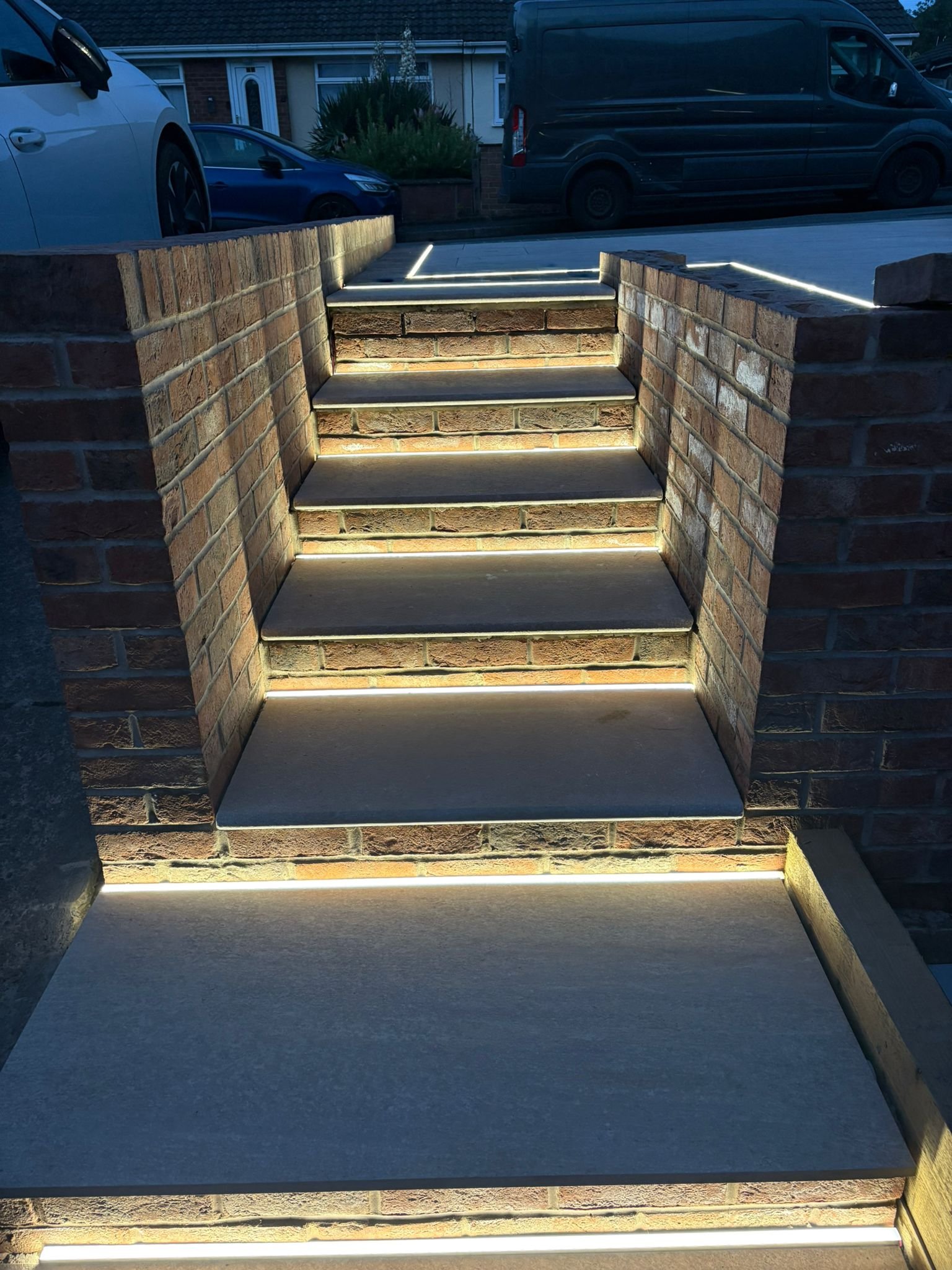Garden steps between brick walls with lighting beneath each tread