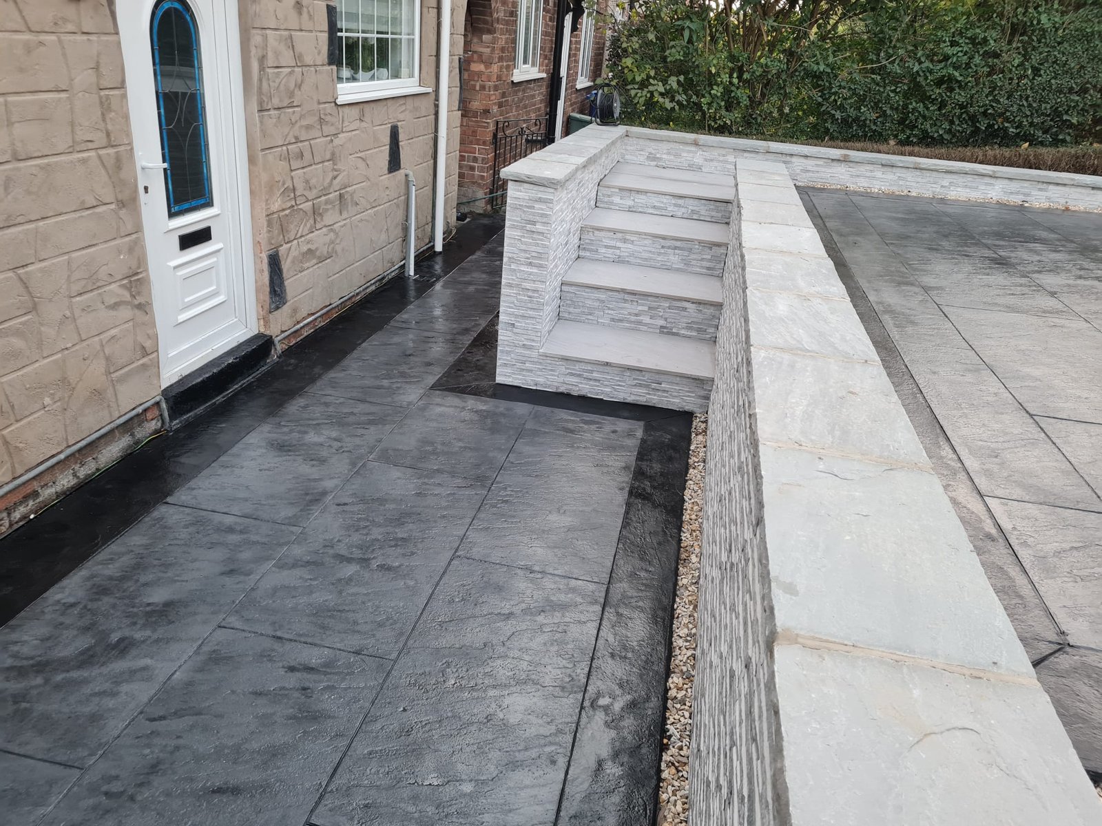 Split-level driveway and paving connected by pale steps